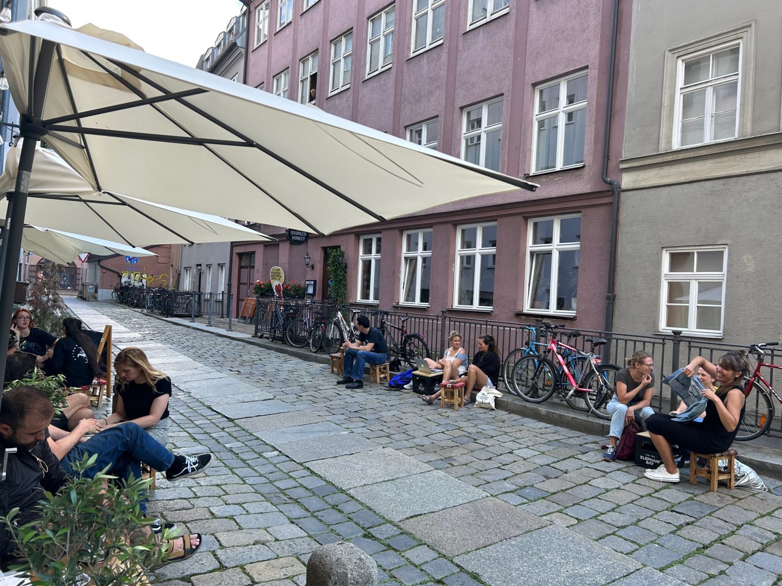 Gemütlich auf den kleinen Hockern in der schmalen Gasse